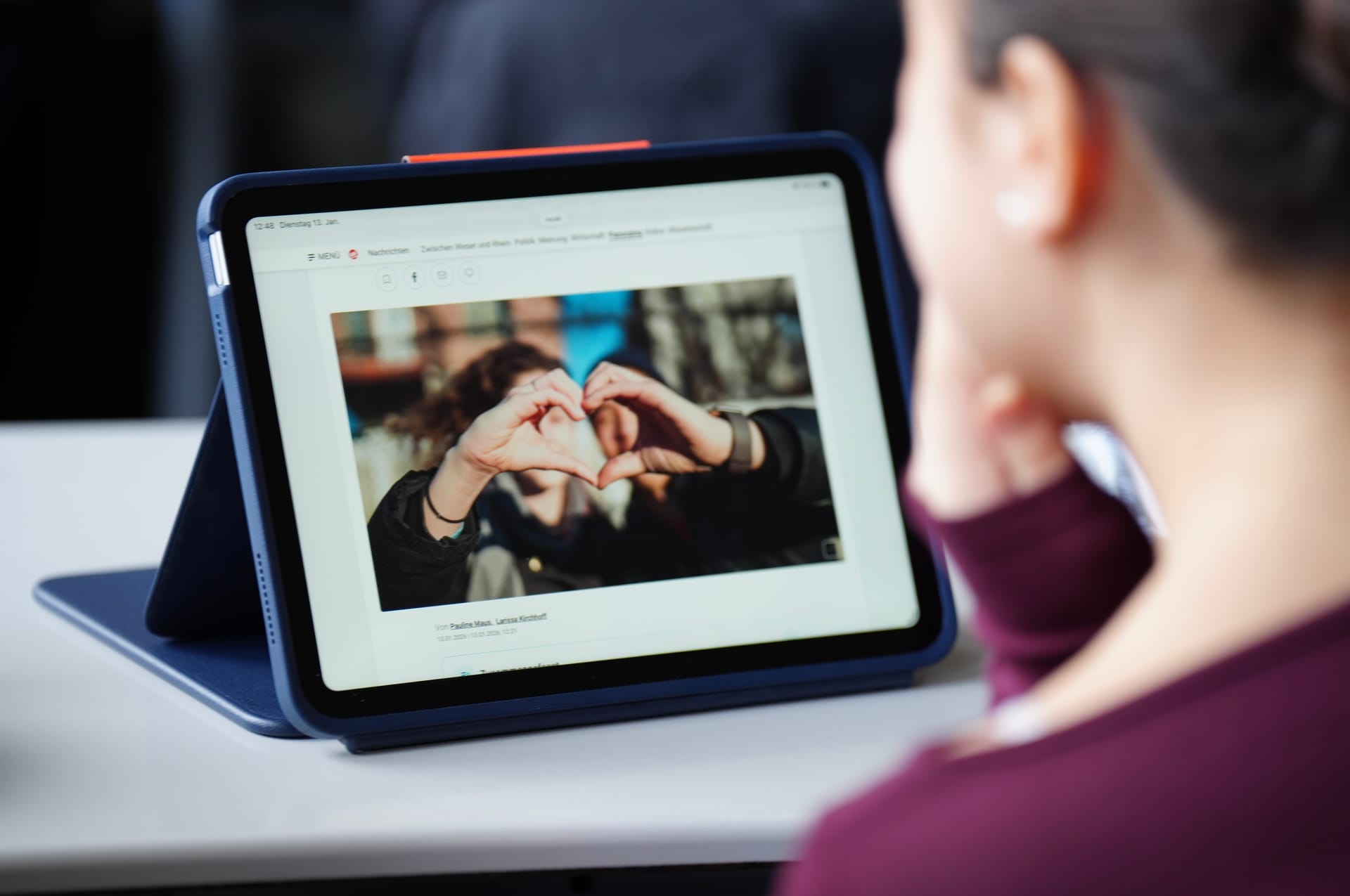 Schülerin liest einen Artikel auf einem Tablet