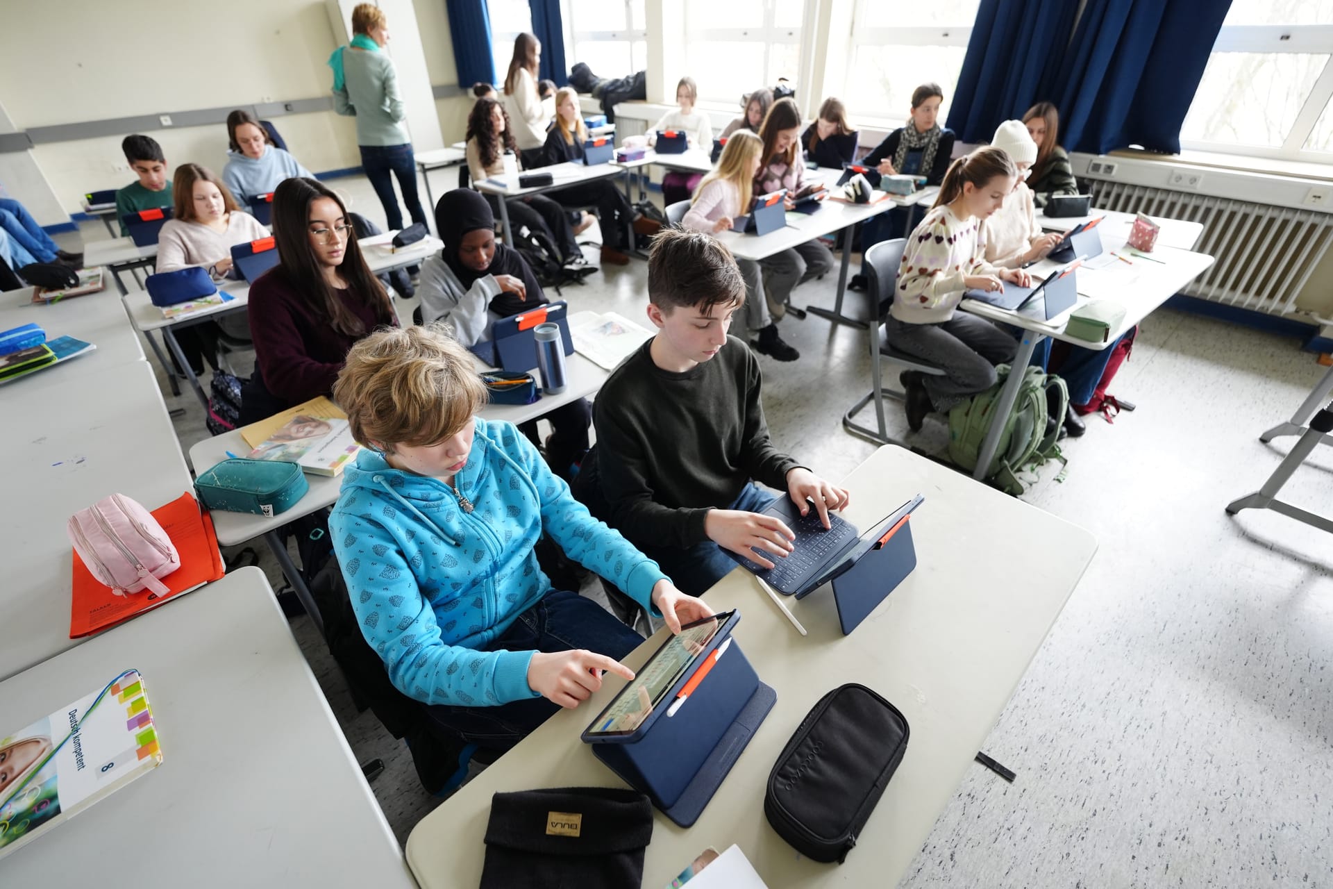 Schülerinnen und Schüler arbeiten mit Tablets im Unterricht