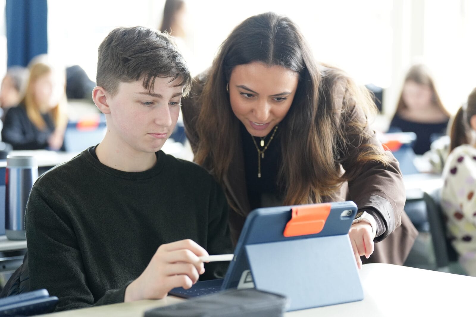 Journalistin arbeitet mit Schüler am Tablet