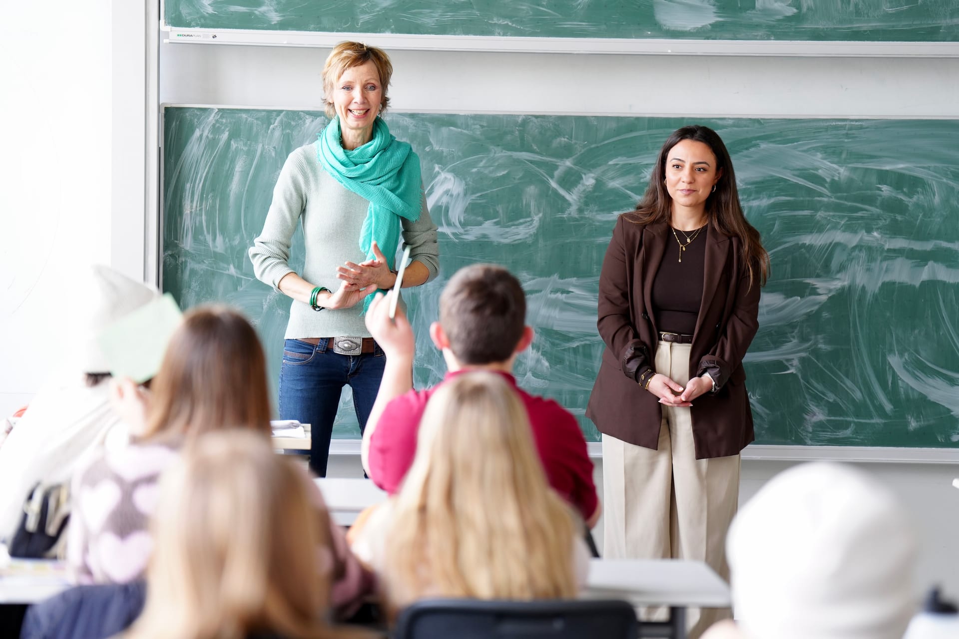 Lehrerin zeigt Schülern die Zeitung im Klassenzimmer